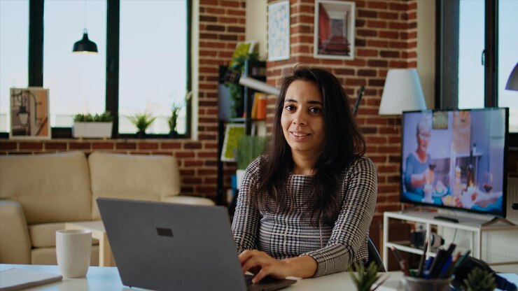 Foto gratuito retrato de un estudiante remoto sonriente escribiendo datos en el teclado y tomando notas
