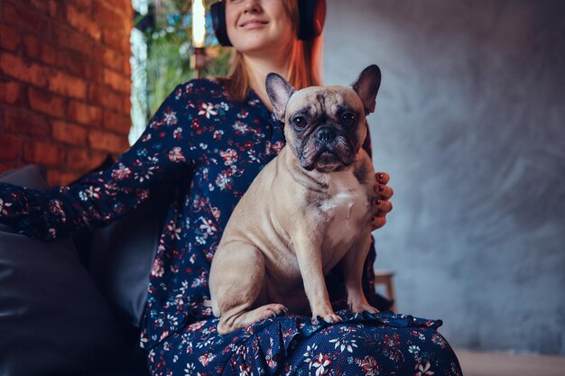 Retrato de estudio de una atractiva rubia feliz en una habitación con un interior tipo loft.