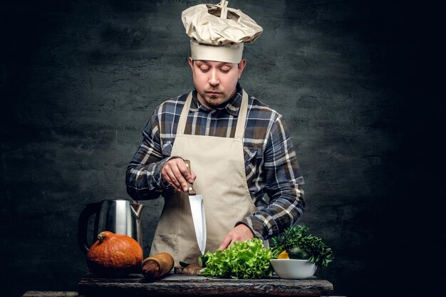 Retrato de estudio de chef masculino preparando ensalada saludable.