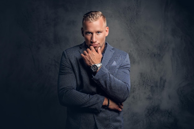 Retrato de estudio de un elegante hombre rubio vestido con un traje azul.