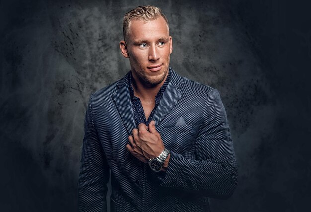 Retrato de estudio de un elegante hombre rubio vestido con un traje azul.