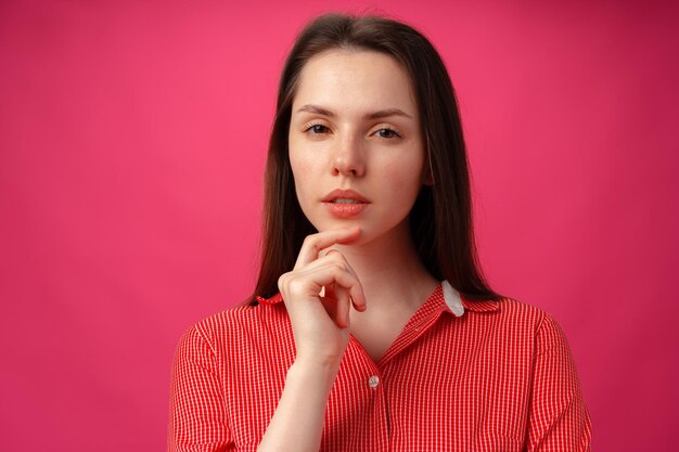 Retrato de estudio de hermosa joven pensando sobre fondo rosa