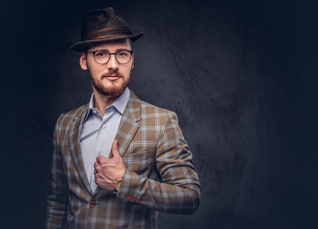 Retrato de estudio de un hipster barbudo con sombrero y gafas