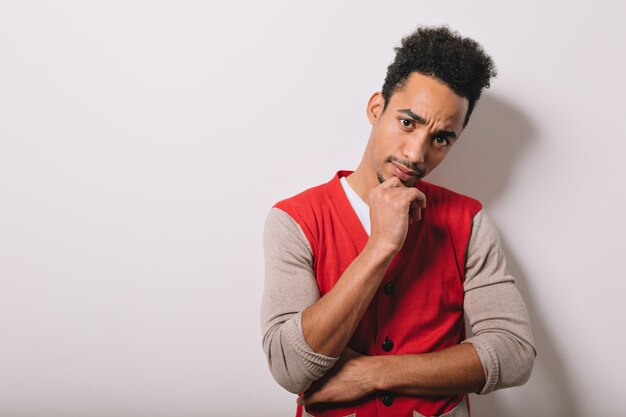 Retrato de estudio de hombre americano negro serio vestido con una camisa roja sobre gris