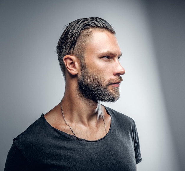 Retrato de estudio de hombre moderno de moda en camiseta gris.