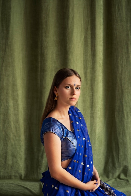 Retrato de estudio de mujer joven vistiendo una prenda tradicional sari