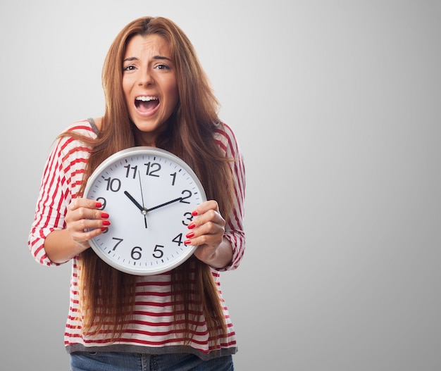 Retrato del estudio de la mujer que sostiene el reloj grande