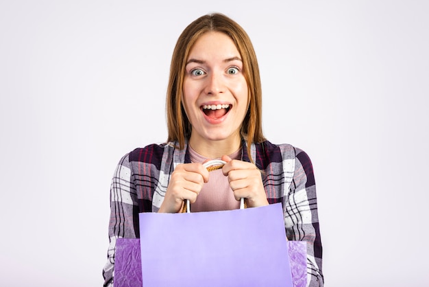 Foto gratuita retrato excitada mujer sosteniendo bolsas y mirando a cámara