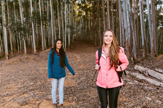 Retrato de un excursionista femenino feliz con su amigo en el bosque