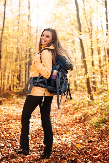Retrato de excursionista hermosa y sonriente con mochila