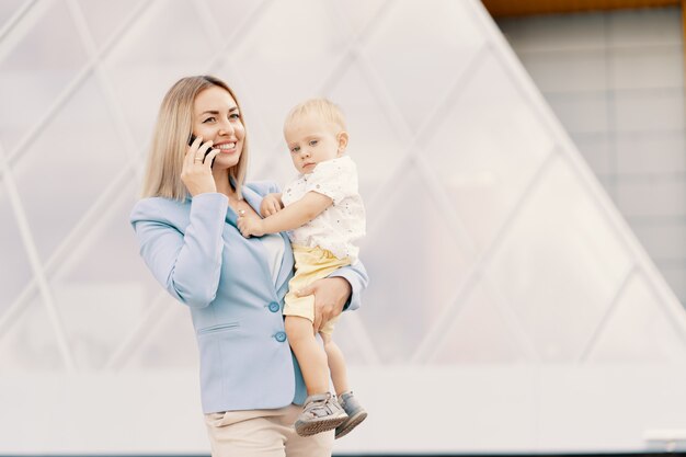 Retrato de una exitosa mujer de negocios en traje azul con bebé