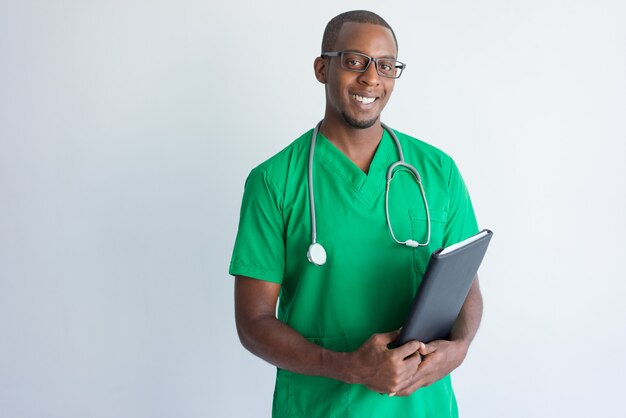 Retrato de exitoso joven médico con carpeta y estetoscopio.