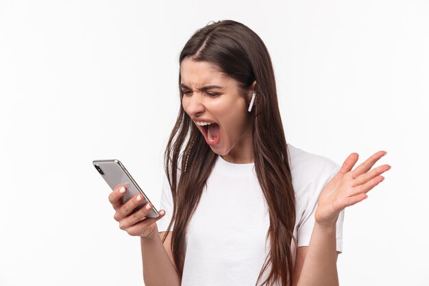 retrato, expresivo, mujer joven, con, airpods, y, móvil