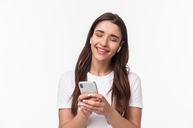 retrato, expresivo, mujer joven, con, airpods, y, móvil