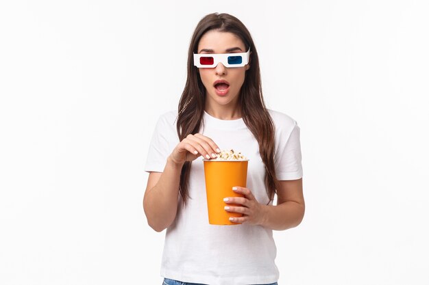 retrato, expresivo, mujer joven, comida, palomitas, y, llevando, lentes 3d