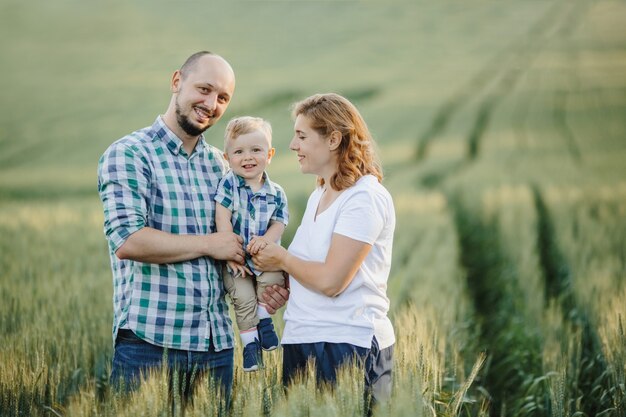 Retrato de familia adorable entre el campo verde