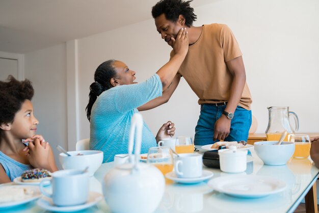 Retrato de familia afroamericana desayunando juntos en casa. Concepto de familia y estilo de vida.