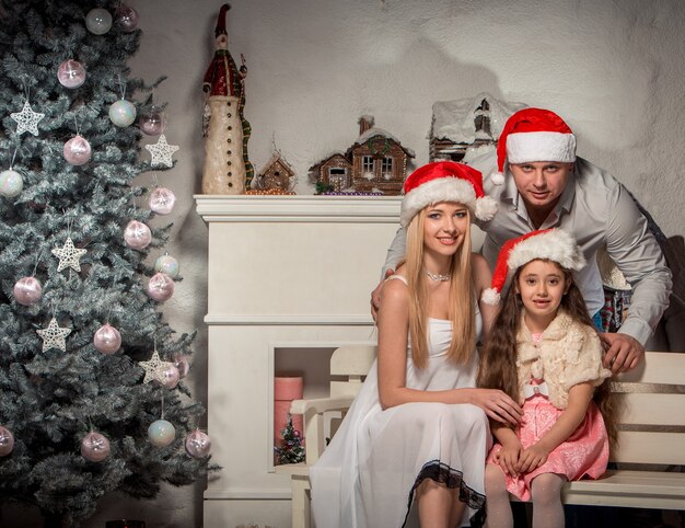 Retrato de familia amigable mirando a la cámara en la noche de Navidad