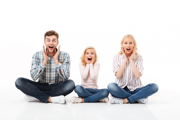 Foto gratuita retrato de una familia emocionada sentados juntos