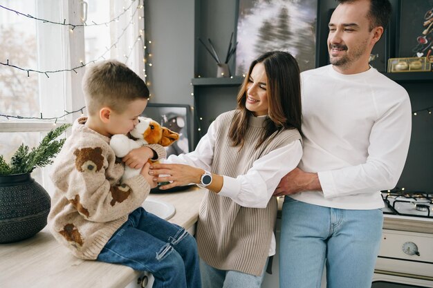 Un retrato de familia feliz en la cocina decorada para navidad