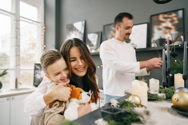 Un retrato de familia feliz en la cocina decorada para navidad