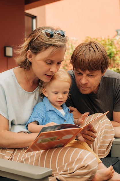 Retrato de familia feliz con libro de lectura para niños