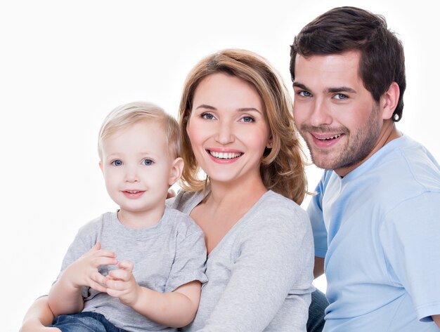 Retrato de la familia feliz con niño pequeño mirando a cámara - aislada