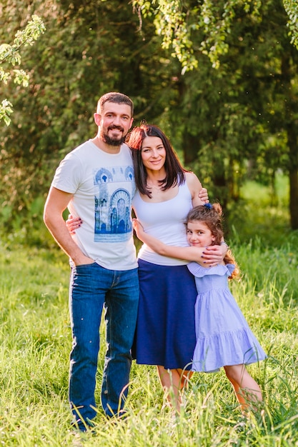 Retrato de familia feliz parado juntos en el parque