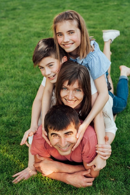 Retrato de la familia feliz que pone en hierba en el parque