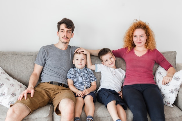 Foto gratuita retrato de una familia feliz sentada en el sofá en casa