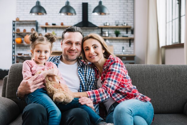 Retrato de familia feliz sentado en el sofá