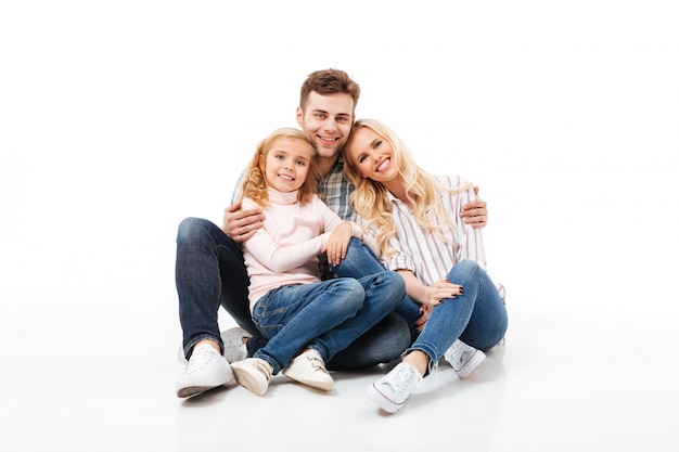 Retrato de una familia feliz sentados juntos y abrazados