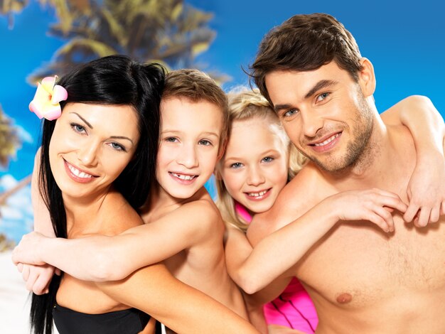 Retrato de familia hermosa sonriente feliz con dos niños en playa tropical