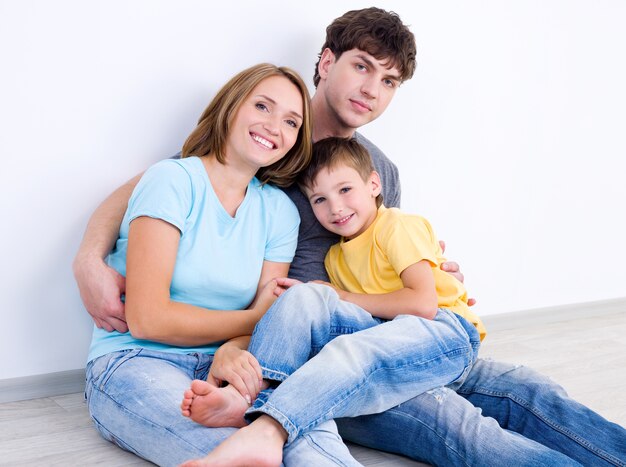 Retrato de familia joven riendo feliz con hijo pequeño - en el interior