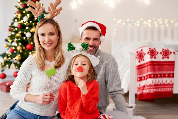 Retrato de familia sonriente en máscaras de Navidad