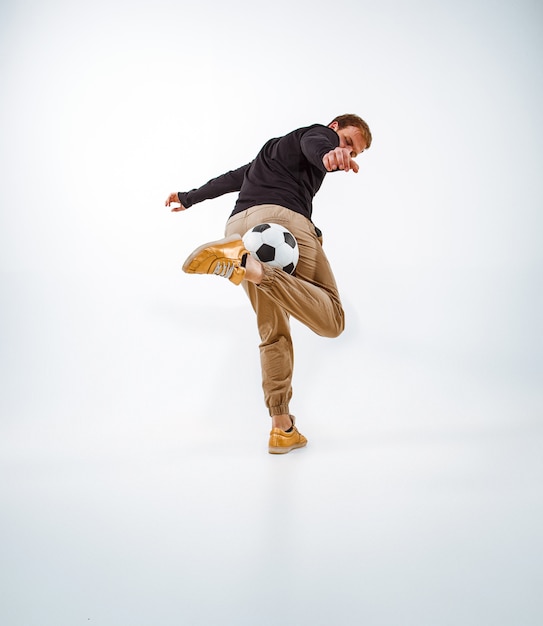 Foto gratuita un retrato de un fan con la bola en fondo gris del estudio. freestile