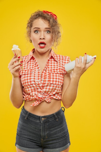 Retrato de fantasía rubia manteniendo crema batida de cono de galleta