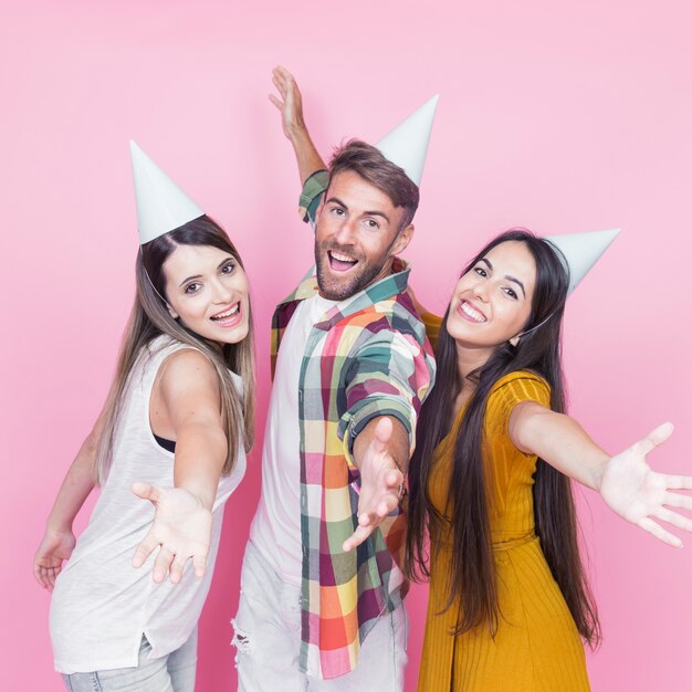 Retrato de feliz amigo con los brazos extendidos sobre fondo rosa