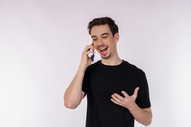Retrato de feliz apuesto hombre de negocios hablando por teléfono móvil y de pie aislado sobre fondo blanco.