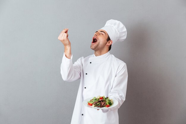 Retrato de un feliz chef hombre vestido con uniforme