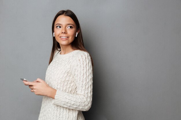 Retrato de una feliz chica atractiva en suéter