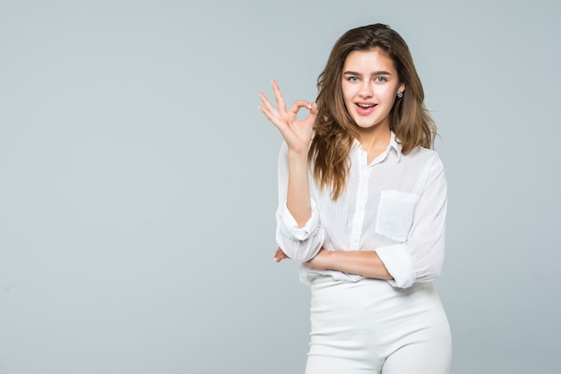 Retrato de feliz empresaria sonriente con gesto bien, sobre fondo blanco.