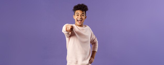 Retrato de un feliz estudiante hispano saliente haciendo su elección riéndose de algo extremadamente