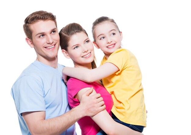 Retrato de la feliz familia joven con niño en camisetas multicolores - aislado en la pared blanca.