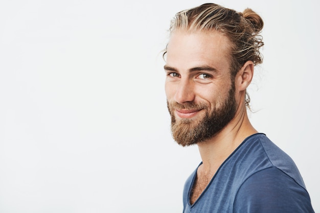 Retrato de feliz joven barbudo con barba y peinado de moda