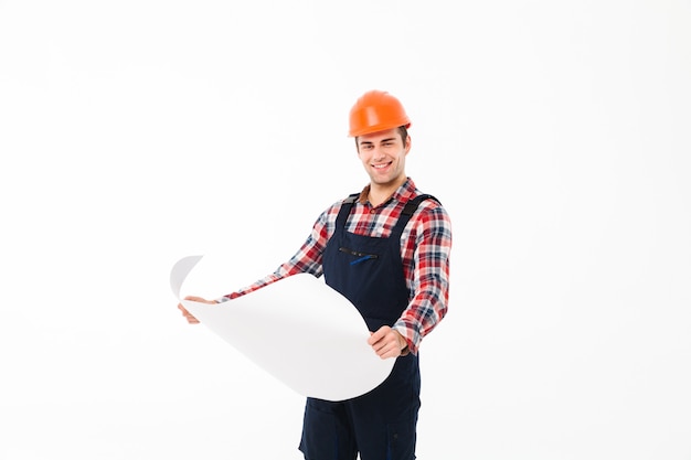 Retrato de un feliz joven constructor masculino con borrador de papel