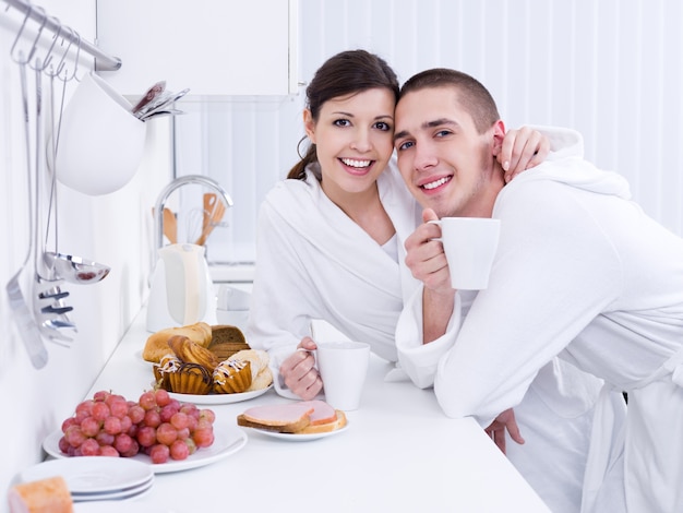 Retrato de feliz joven pareja amorosa desayunando juntos