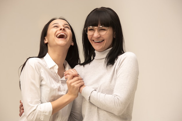 Un retrato de una feliz madre e hija en el estudio en gris