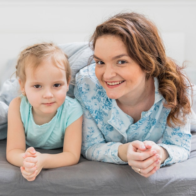 Retrato de feliz madre e hija mirando a cámara