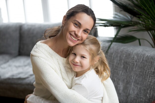 Retrato de feliz madre soltera amorosa abrazando linda hijita